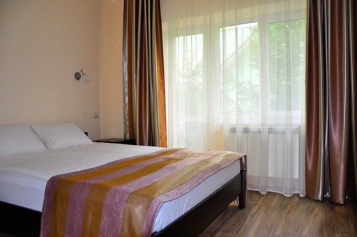 A bedroom with a double bed in a 2-room suite in the estate "Polyana Aqua Resort" in Transcarpathia. Book rooms with a discount.
